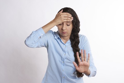 Frustrated woman with hand on forehead and one outstretched